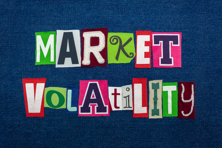 MARKET VOLATILITY text word collage, multi colored fabric on blue denim, unpredictable market direction concept, horizontal aspectの写真素材