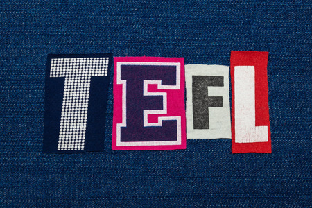 TEFL text word collage, multi colored fabric on blue denim, teach english as a foreign lanuage acronym, horizontal aspectの写真素材