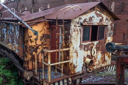 Old rusted train car beside a brick industrial building, horizontal aspectの写真素材