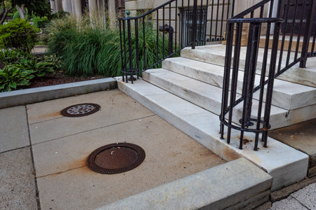 Brownstone entry with marble stairs and iron railings, walkway with manhole covers, beautiful...