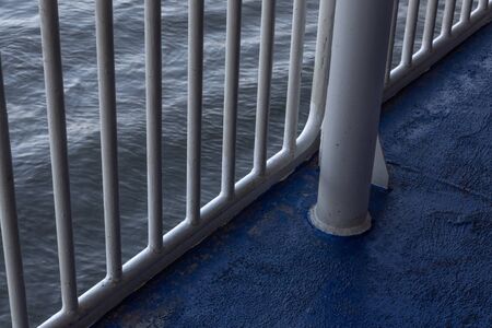 Ocean waters seen through ship railings, early morning light, horizontal aspectの写真素材