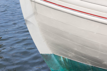 Bow of an old wooden boat, white green and red paint, copy space, horizontal aspect