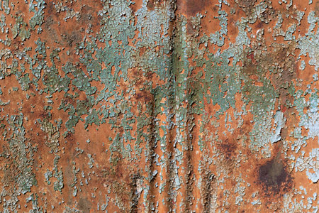 Aqua green paint, checked and crazed, flaking off a rusty metal background, horizontal aspect