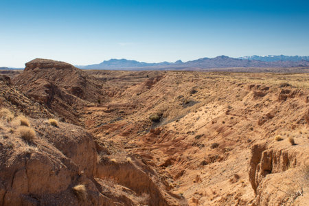 Desert canyon, barren landscape with rocky terrain, distant mountain range in New Mexico, horizontal aspectの写真素材