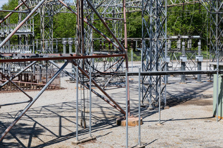 An array of ground supports, trusses, and insulators at an electrical power substation, horizontal...