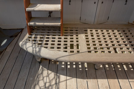Teak boat decking and drain board, ladder on old sailing ship, horizontal aspect