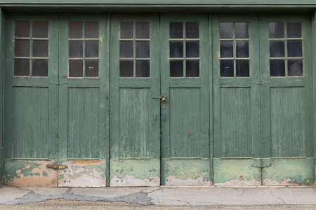 Accordian fold green painted weathered garage doors with windows, creative copy space, horizontal aspectの写真素材