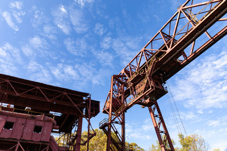 Monumental industrial architecture, metal construction on a derelict manufacturing site, bright blue sky, horizontal aspectの写真素材