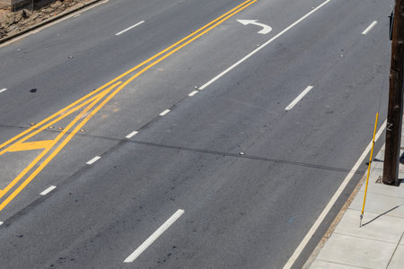 Overhead view of an urban street with four lanes plus a turn lane, asphalt and concrete, horizontal aspectの写真素材
