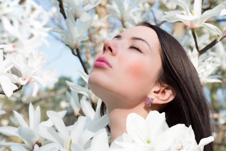 Young woman surrounded by flowers of Magnoliaの写真素材