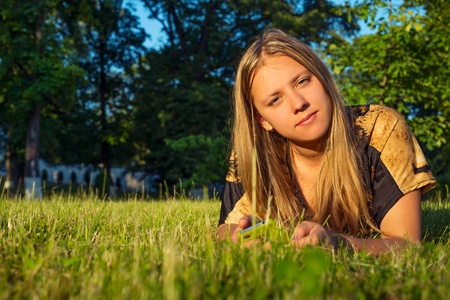 Teen girl with phone in natureの写真素材