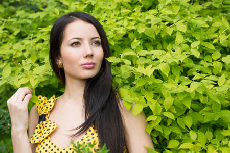 Woman standing near a tree with green leavesの写真素材
