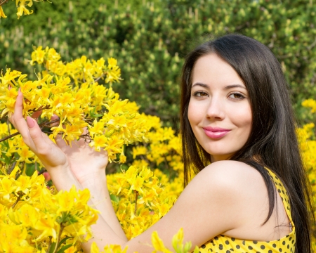 Woman with yellow flowers of rhododendronの写真素材