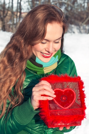 Young woman opens a red box with heart and smilingの写真素材