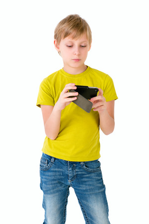 Boy looks to the phone on an isolated backgroundの写真素材