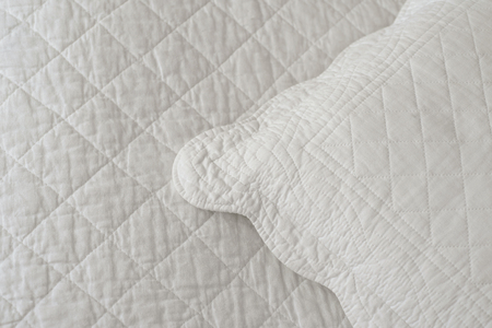 Pillow lies on a blanket made of natural textilesの写真素材