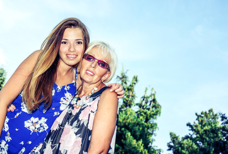 Portrait of two women in the summer outdoors. Mother and daughter hugging. Grandmother and granddaughter.の写真素材