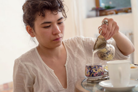 Asian woman pours a cup of creamの写真素材