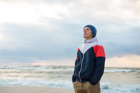 Portrait of young men in sportswear and hat near the seaの写真素材