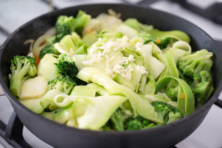 Fresh green vegetables stewed in a frying panの写真素材