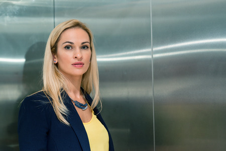 Portrait of a blonde woman in an elevatorの写真素材