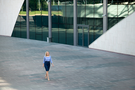 Business woman in a skirt walking down the streetの写真素材