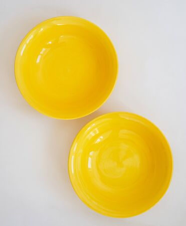 Two yellow plates on a white backgroundの写真素材