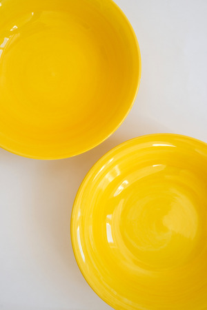 Two yellow plates on a white backgroundの写真素材