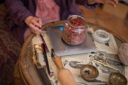 Female seller weighs on electronic weighers goji berriesの写真素材