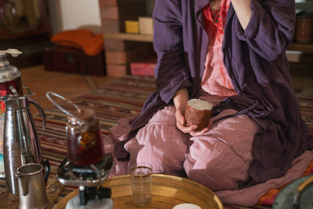 Woman drinking tea from a clay mugの写真素材