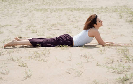 Young brunette woman lies on the sand