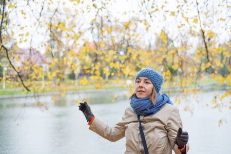 Cheerful woman is walking in the park in autumnの写真素材