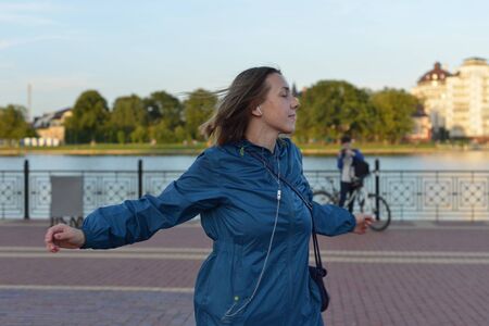 Young woman in headphones dancing on the streetの写真素材