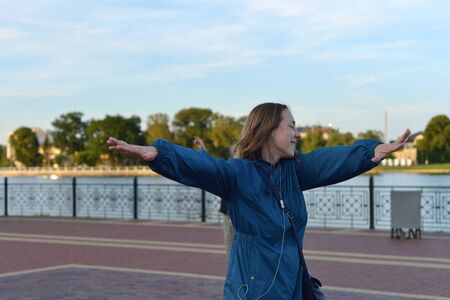 Young woman in headphones dancing on the streetの写真素材