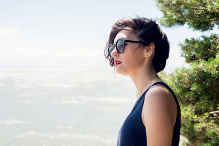 Portrait of a brunette woman with a haircut in a profile on the natureの写真素材