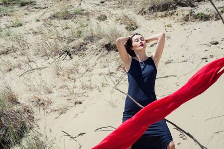 Portrait of a young brunette woman in nature with a red scarfの写真素材