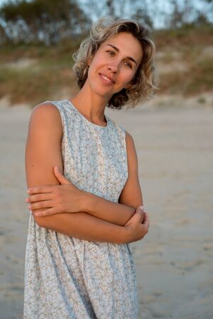 Natural portrait of a blonde woman in a dress near the seaの写真素材