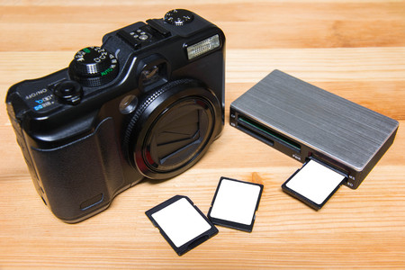 usb card reader with 3 cards and camera on wooden table ready to useの写真素材