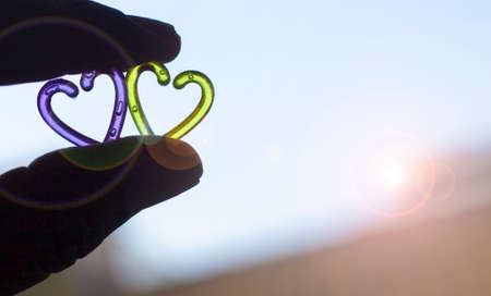 Silhouette hand holding plastic heart with blurred background.Valentine day concept.の写真素材