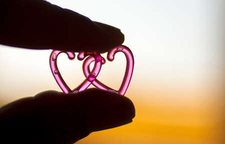 Silhouette hand holding plastic heart with blurred background.Valentine day concept.の写真素材