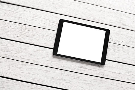 Tablet computer on white wooden desk. Clipping path included.の写真素材
