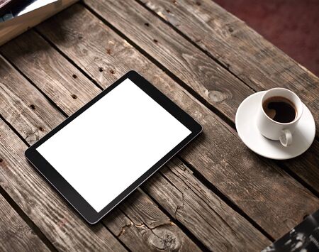 Digital tablet computer with isolated screen on wooden table with cup of coffeeの写真素材