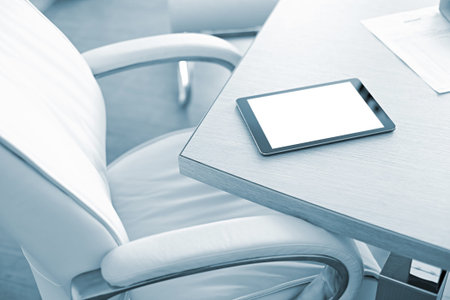 Digital tablet computer with isolated screen on office desk. At office interior.