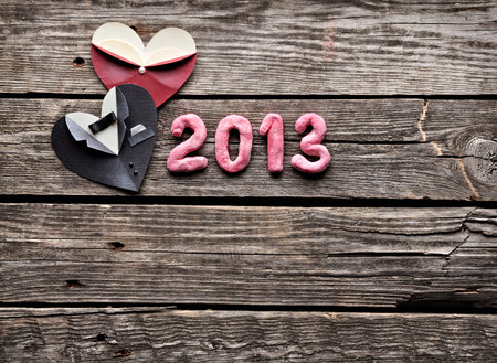 Symbolic male and female heart shapes with 2013 numbers. On old vintage wooden background.