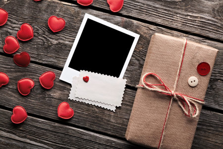 Blank photo frame and vintage gift box (package) with blank gift tag on old wooden background.の写真素材