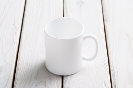 White empty cup mock-up in the center of wooden tableの写真素材