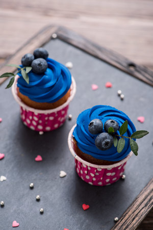 Two delicious cupcakes over wooden deskkop, closeup shotの写真素材