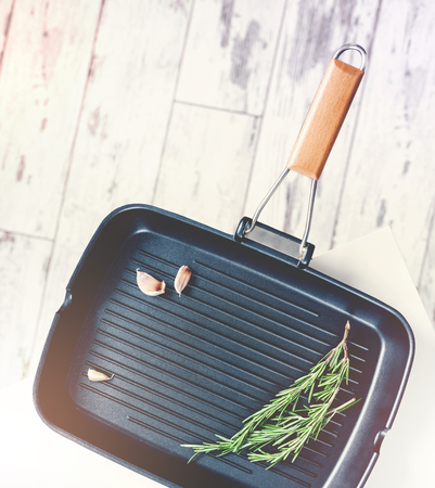 Grill pan with garlic and sprig of rosemary, top view.の写真素材