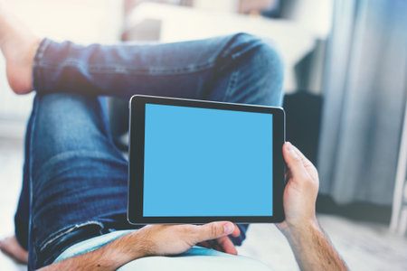 Man Using Tablet PC While Lying on a Floor. View from above. Clipping path included.