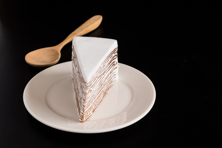 white layer cake chocolate in white dish on black backgroundの写真素材